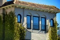 Modern house building with bay style window blue glass with square exterior white stucco and red roof tiles Royalty Free Stock Photo