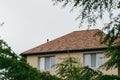 Modern house with chimney, red clay tiled roof and gable and valley type of roof construction. Roofing Construction. Royalty Free Stock Photo