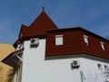 Modern house with white stucco elevation and brown steep Mansard roof