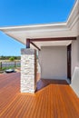 Modern house entrance from the side with wooden floor and a stone pillar like a brick wall Royalty Free Stock Photo