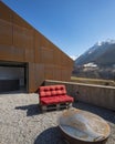 Modern house exteriors with veranda. Red sofa overlooking the mountains of Switzerland Royalty Free Stock Photo