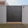 A modern house external entrance dark grey metallic door by the sidewalk