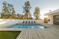 Modern house garden swimming pool and wooden deck Royalty Free Stock Photo