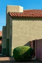 Modern house or home with adobe desert style and visible red or orange roof tiles and front yard shrub with blue sky Royalty Free Stock Photo