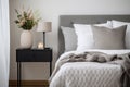 Modern house interior details. Simple cozy bedroom interior with gray bed headboard, linen bedding, bedside table and Royalty Free Stock Photo