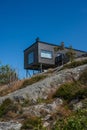 Modern house on stilted supports on rocky hillside.. Royalty Free Stock Photo