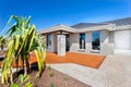 Modern house with a tree and the garage with wooden and stone ya Royalty Free Stock Photo