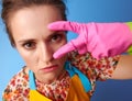 Modern housewife with rubber gloves on blue
