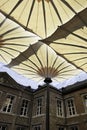 Alden Biesen castle with moat and modern huge umbrellas in Bilzen, Belgium