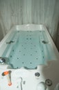 Modern hydro-massage bath filled with water in a balneological resort in a luxury hotel or Spa, vertical shot, relaxation and Royalty Free Stock Photo