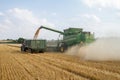 Modern 9780i cts john deere combine harvester cutting crops corn wheat barley working golden field
