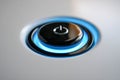 Modern illuminated power button glowing with soft blue light on sleek electronic device surface symbolizing standby mode and user Royalty Free Stock Photo