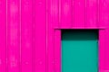 Modern industrialism. Neon pink building with green door. Vibrant paint color choice.