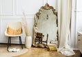 Modern interior in boho style. Large shaped mirror, wicker chair and rug in the room