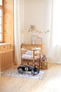 Modern interior of a children`s bedroom. Copy space. Hygge. Kindergarten. Cozy Scandinavian lights baby room: wooden crib with bed Royalty Free Stock Photo