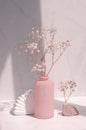 Geometric shape, natural stone, decorative pink vase and gypsophila flowers