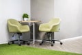 modern interior with concrete walls with two office chairs and a round wooden table Royalty Free Stock Photo
