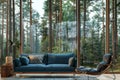 Modern interior design with a blue sofa and chair in a room with floor-to-ceiling windows overlooking a pine forest Royalty Free Stock Photo