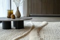 Modern interior design featuring a minimalist table with decorative elements on a textured rug in a spacious living area Royalty Free Stock Photo