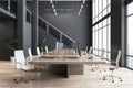Modern interior design of spacious office hall with wooden meeting table surrounded by light stylish wheel chairs on parquet with Royalty Free Stock Photo