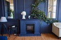 Modern interior with fireplace, spacious living room with dark blue walls and wooden floor.