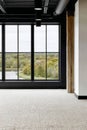 Modern interior with large windows showcasing a serene landscape view of trees and water Royalty Free Stock Photo