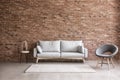 Modern interior of living room with comfortable sofa and armchair near brick wall Royalty Free Stock Photo