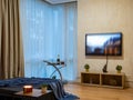 Modern interior of living room with lounge zone. TV on wall. Panorama windows.