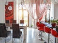 Modern interior of a red white living room with a bar area and a dining business business table in a large room. The