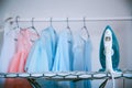 Modern iron and clothes in dry-cleaning salon blue