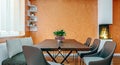 Modern italian design dining room with small fireplace and orange plaster walls, mock-up Royalty Free Stock Photo