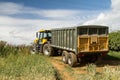 Modern JCB fast trac tractor pulling green yellow trailer Royalty Free Stock Photo