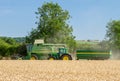 Modern John Deere combine harvester cutting crops with tractor and trailer Royalty Free Stock Photo