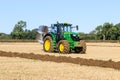 Modern John Deere 6195R green tractor ploughing