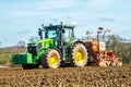 Modern John Deere tractor drilling seed in field