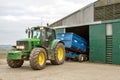 Modern John Deere tractor parking blue trailer