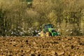 Modern John Deere tractor pulling a plough followed by gulls Royalty Free Stock Photo