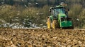 Modern John Deere tractor pulling a plough followed by gulls Royalty Free Stock Photo