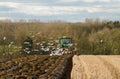 Modern John Deere tractor pulling a plough followed by gulls Royalty Free Stock Photo