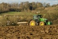 Modern John Deere tractor pulling a plough followed by gulls