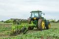 Modern John Deere tractor pulling a plough