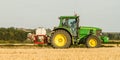 Modern john deere tractor Tractor spraying field stubble crops Royalty Free Stock Photo