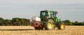 Modern john deere tractor Tractor spraying field stubble crops