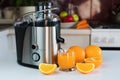 Modern juicer, glass of fresh orange juice and oranges on the table in the kitchen. Natural and healthy juices. Close-up Royalty Free Stock Photo