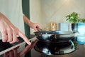 Woman turn on induction hob with frying pan Royalty Free Stock Photo