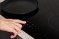 Woman hand turns on modern induction stove in the kitchen Royalty Free Stock Photo