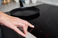 Woman hand turns on modern induction stove in the kitchen Royalty Free Stock Photo