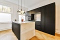 a kitchen with black cabinets and a white marble island Royalty Free Stock Photo