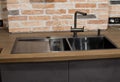 Modern kitchen with black sink, kitchen faucet for water and fronts against the background of a brick wal Royalty Free Stock Photo