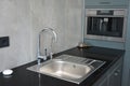 Modern kitchen  with chrome faucet, water tap, black kitchen table, coffee mashine and  kitchen sink Royalty Free Stock Photo